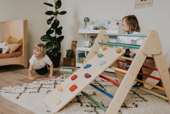 Kinder spielen auf Pikler Dreieck