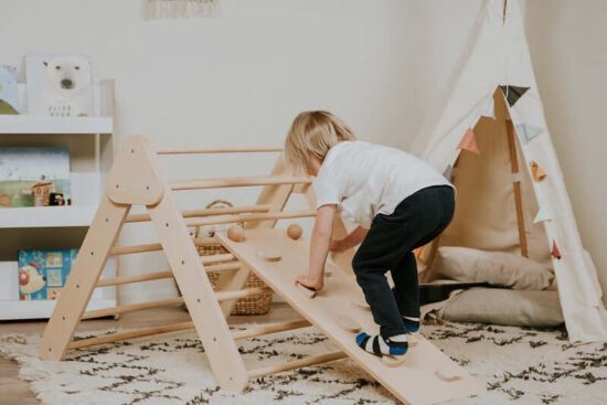 Baby lernt laufen am Kletterdreieck