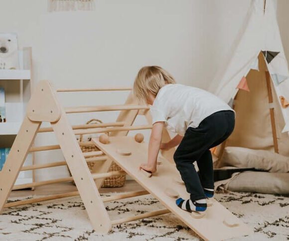 Baby lernt laufen am Kletterdreieck
